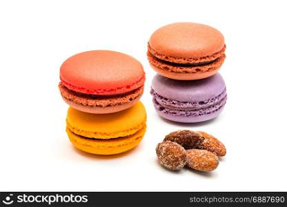 Fresh macarons and almonds on white background