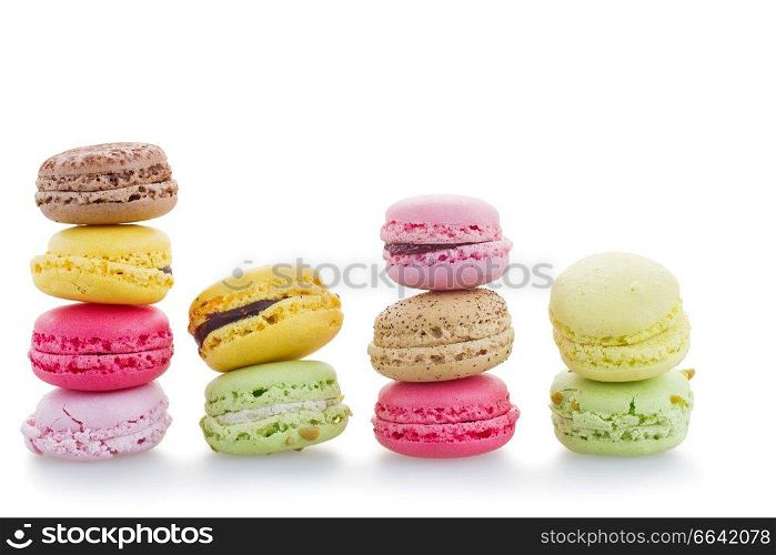 Fresh macaroons stacked in a row against white background