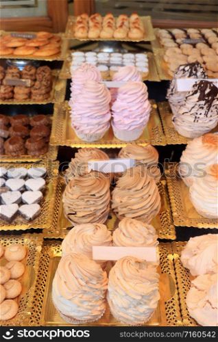 Fresh made meringue confectionery, made from whipped egg whites and sugar. Cupcakes in various pastel colors in a Spanish shop.