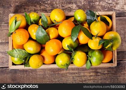 fresh mandarin oranges fruit with leaves in wooden box