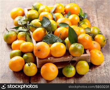 fresh mandarin oranges fruit with leaves in wooden box