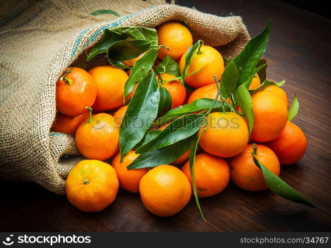 fresh mandarin oranges fruit with leaves on wooden table