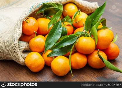 fresh mandarin oranges fruit with leaves on wooden table