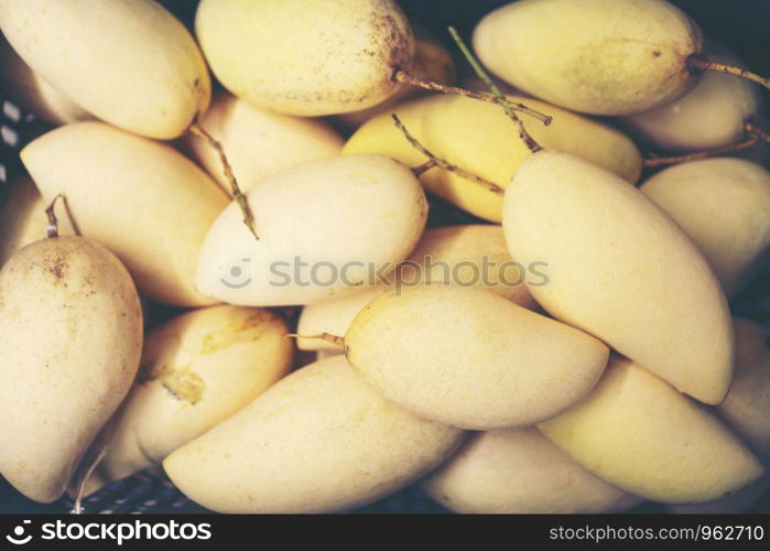 Fresh mangoes on display at outdoor farmers market in Thailand