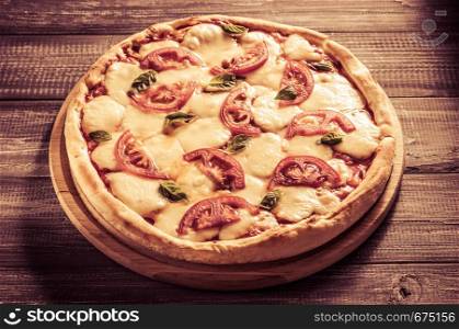 fresh margarita pizza at wooden table