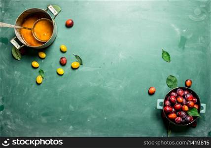 Fresh mashed ripe plums. On a chalkboard.. Fresh mashed ripe plums.