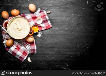 Fresh mayonnaise with the eggs and olive oil. On a black chalkboard.. Fresh mayonnaise with the eggs and olive oil.