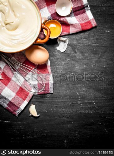Fresh mayonnaise with the eggs and olive oil. On a black chalkboard.. Fresh mayonnaise with the eggs and olive oil.