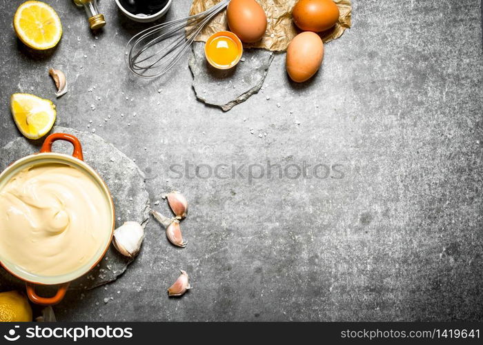 Fresh mayonnaise with the ingredients and whisk. On the stone table.. Fresh mayonnaise with the ingredients and whisk.