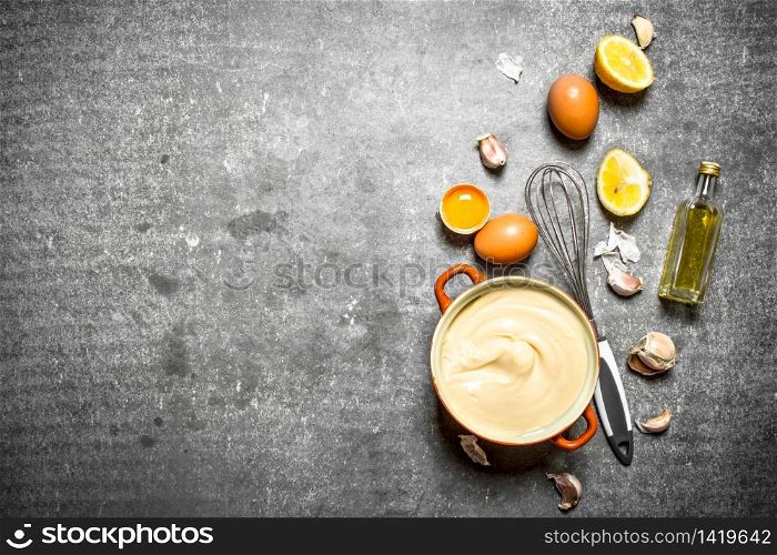Fresh mayonnaise with the ingredients and whisk. On the stone table.. Fresh mayonnaise with the ingredients and whisk.