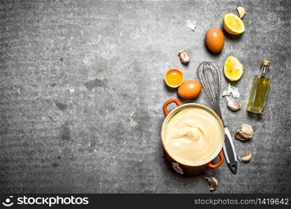 Fresh mayonnaise with the ingredients and whisk. On the stone table.. Fresh mayonnaise with the ingredients and whisk.