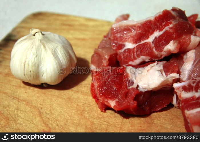 Fresh meat and fresh garlic laying on the kitchen desk