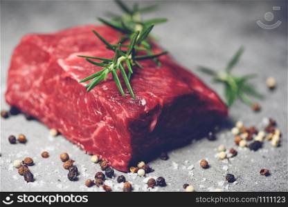 Fresh meat beef sliced on black background / Raw beef steak with herb and spices and rosemary on plate