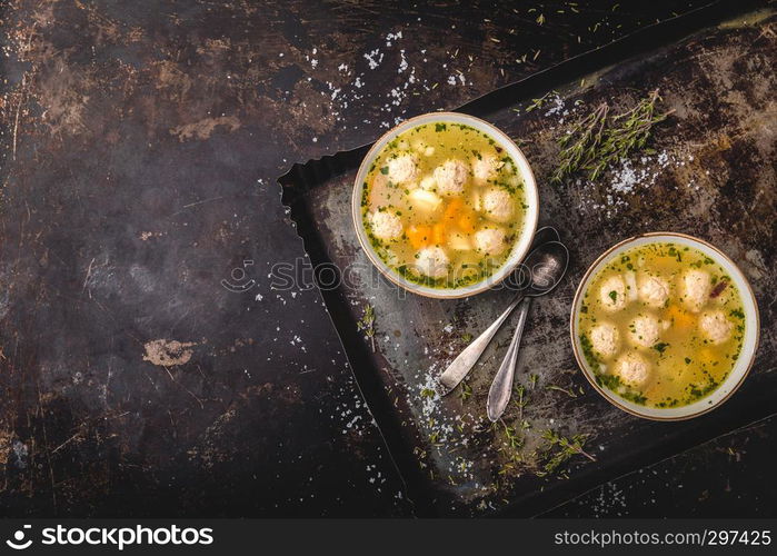 Fresh meat soup in bowl on dark background, top view