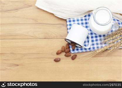 Fresh milk and almonds on wood table with free copy space for text.