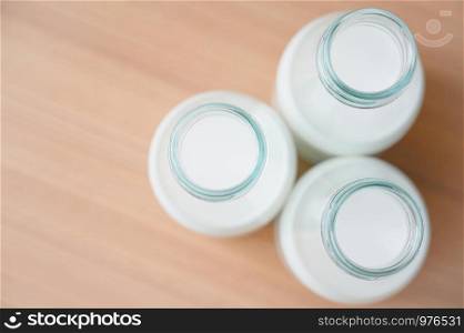 Fresh milk bottles without cap on wooden table. A healthy drink concept. Copy space wallpaper.