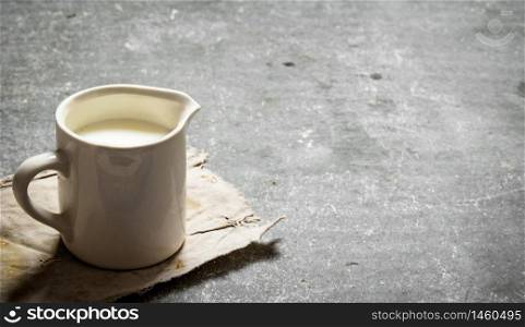 Fresh milk in a mug. On the stone table.. Fresh milk in a mug.