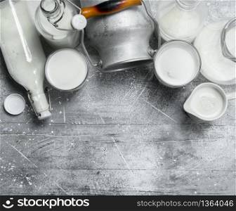 Fresh milk in glasses, bottles and jug. On a rustic background .. Fresh milk in glasses, bottles and jug.