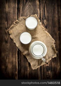 Fresh milk in jug and glasses . On a wooden table.. Fresh milk in jug and glasses .