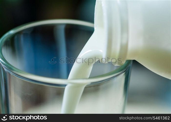 Fresh milk poured in glass cup over indoors background