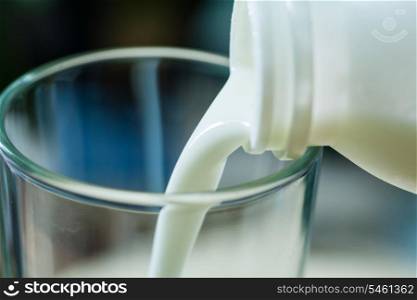 Fresh milk poured in glass cup over indoors background
