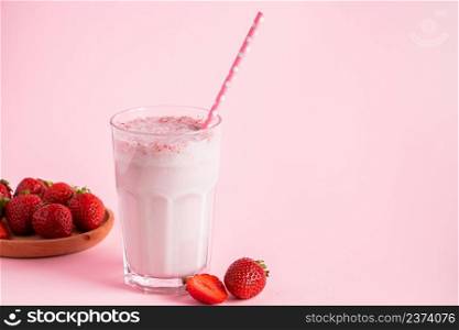Fresh milkshake with strawberries on a pink background. Summer drink with berries in a glass. Place for text.. Fresh milkshake with strawberries on pink background. Summer drink with berries in a glass. Place for text.