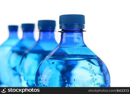 Fresh mineral water concept - cool bottles of mineral water in a row on a white background in close-up.