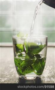 Fresh mint tea near the window. Cozy home or health concept