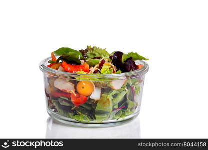 Fresh mixed salad in glass container isolated on white with reflection