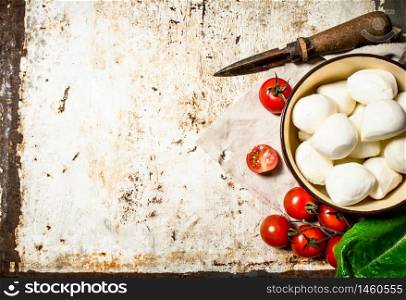 Fresh mozzarella with tomatoes and greens. On rustic background .. Fresh mozzarella with tomatoes and greens.