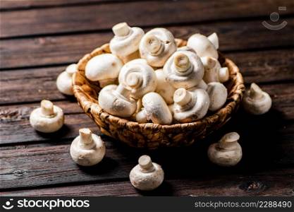 Fresh mushrooms in a basket. On a wooden background. High quality photo. Fresh mushrooms in a basket.