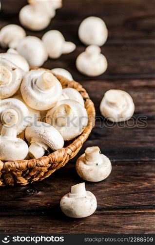 Fresh mushrooms in a basket. On a wooden background. High quality photo. Fresh mushrooms in a basket.