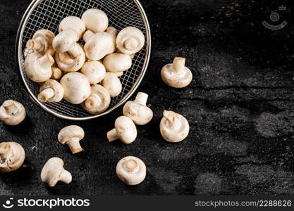 Fresh mushrooms in a colander. On a black background. High quality photo. Fresh mushrooms in a colander.