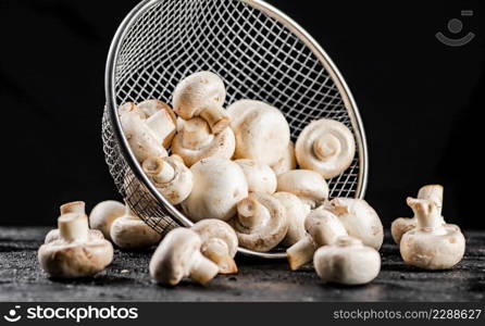 Fresh mushrooms in a colander. On a black background. High quality photo. Fresh mushrooms in a colander.