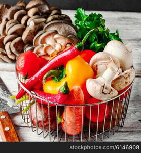 Fresh mushrooms,tomatoes,peppers and onions on a light wooden background