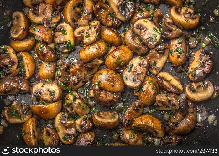 fresh mushrooms with herbs fried on a plate, top view,