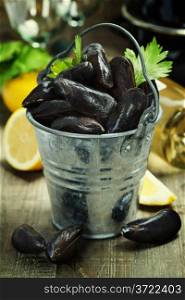 Fresh mussels ready for cooking on wooden background