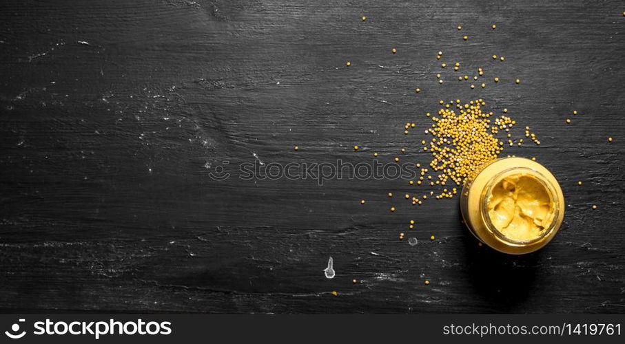 Fresh mustard in jar with seeds. On a black chalkboard.. Fresh mustard in jar with seeds.