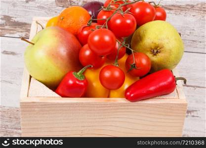 Fresh natural fruits and vegetables in wooden box. Nutritious food containing healthy minerals and vitamins. Fresh fruits and vegetables in wooden box. Food containing healthy minerals and vitamins