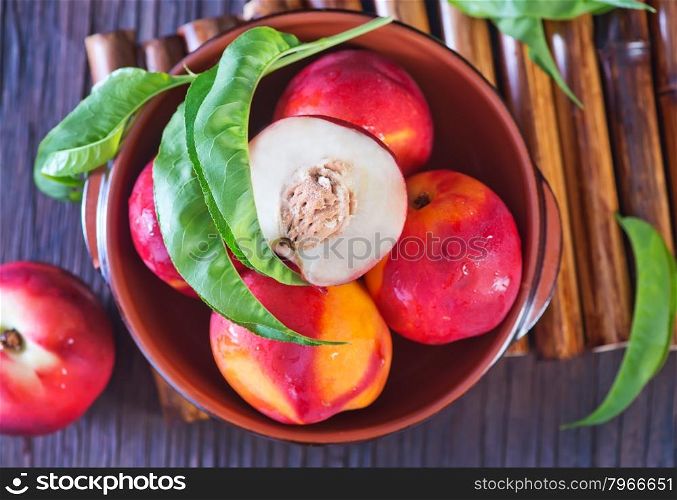 fresh nectarine in bowl and on a table