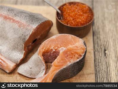 Fresh Norwegian rainbow trout with red caviar on a wooden background. Fresh Norwegian rainbow trout with red caviar on a wooden background.