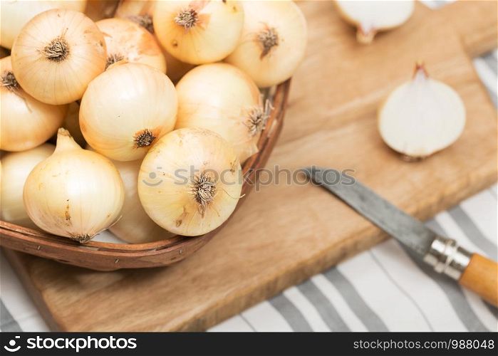 Fresh Onions on basket. Rustic style