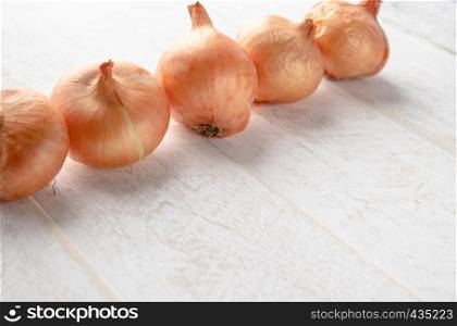 Fresh onions on wooden background. Vegetables for a healthy diet. Vegan food. Yellow onion. Fresh onions on wooden background. Vegetables for a healthy diet. Vegan food.