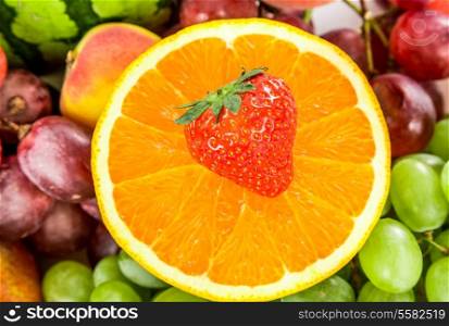 Fresh Orange and strawberries on a background of different fruits and grapes