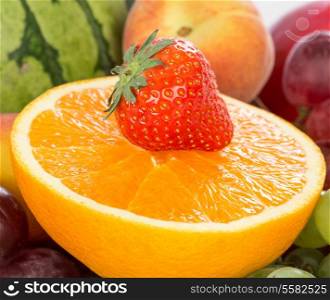 Fresh Orange and strawberries on a background of different fruits and grapes