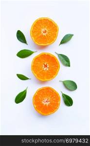 Fresh orange citrus fruit with green leaves on white background.