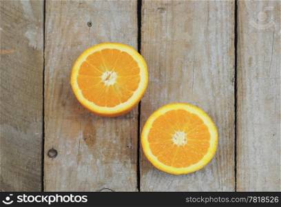 Fresh orange cut in half on wooden table