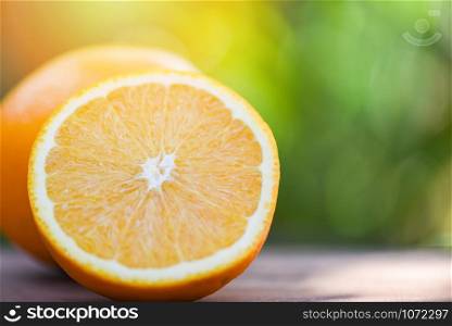 Fresh orange fruit slice half on summer nature background