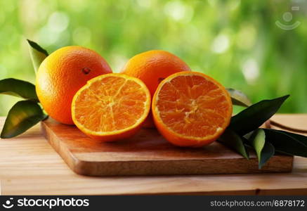 fresh orange fruit with leaf on green background