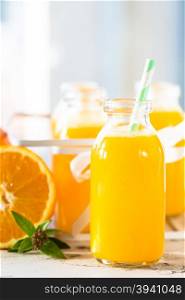 Fresh orange juice in bottle with cane